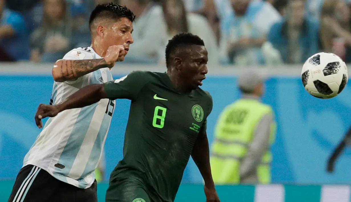 Pemain timnas Nigeria, Oghenekaro Etebo berebut bola dengan pemain Argentina, Enzo Perez pada matchday terakhir Grup D Piala Dunia 2018 di Stadion St Petersburg, Selasa (26/6). Argentina meraih tiket ke 16 besar setelah menang 2-1. (AP/Dmitri Lovetsky)