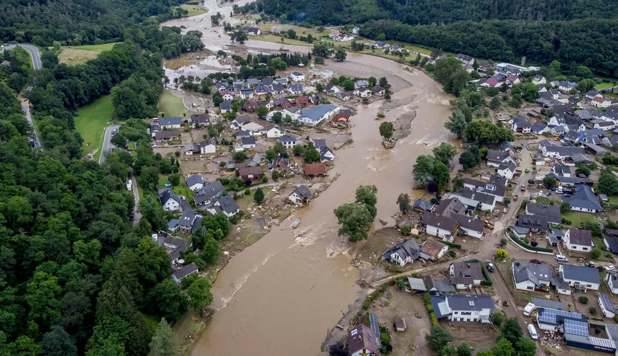 Air Sungai Ahr melewati rumah-rumah yang hancur akibat dilanda banjir di Schuld, Jerman, Kamis (15/7/2021). Banjir ini menyebabkan ribuan orang dievakuasi, dan memberi dampak besar ke wilayah Jerman yang berada di perbatasan Belgia, Prancis, Luxembourg, dan Belanda. (AP Photo/Michael Probst)