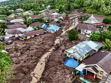 Foto udara tim penyelamat dan warga melakukan pencarian korban yang tertimbun akibat banjir bandangdi Kelurahan Rua, Kota Ternate, Maluku Utara, Minggu (25/8/2024). (AZZAM RISQULLAH / AFP)