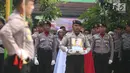 Personel kepolisian membawa foto jenazah Bripda Imam Gilang Adinata (24) yang gugur akibat bom Kampung Melayu, ketika upacara pelepasan di Menteng Dalam, Kamis (25/5). Briptu (anumerta) Imam akan dimakamkan di Klaten, Jateng. (Liputan6.com/Angga Yuniar)