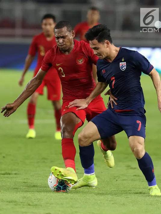 Bek Timnas Indonesia, Yustinus Paew (kiri) berebut bola dengan pemain Thailand, Supachok Sarachat pada laga Grup G Penyisihan Kualifikasi Piala Dunia 2022 zona Asia di Stadion Utama Gelora Bung Karno, Jakarta, Selasa (10/9/2019). Indonesia kalah 0-3. (Liputan6.com/Helmi Fithriansyah)