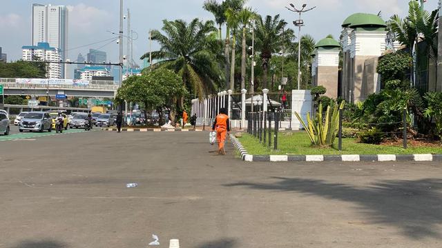 Nampak petugas kebersihan membersihkan depan gerbang Gedung DPR RI usai demonstrasi penolakan RUU Kesehatan pada Selasa, 11 Juli 2023.