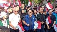 Ketua Umum PSSI, Erick Thohir (tengah), didampingi Wali Kota Surabaya, Eri Cahyadi (dua kanan) saat mengikuti pawai yang dilakukan mulai area Siola menuju Balai Pemuda Surabaya dalam rangkaian acara Trophy Experience Piala Dunia U-17 2023 di Surabaya, Minggu (29/10/2023). (Bola.com/Aditya Wany)