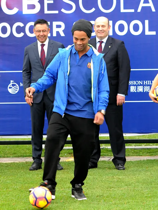 Pemain sepak bola asal Brasil, Ronaldinho beraksi memainkan bola saat peluncuran akademi sepak bola di China (24/2). Fasilitas akademi ini akan menjadi yang terbesar dari 20 akademi sepak bola Barcelona di seluruh dunia. (Handout / Mission Hills / AFP)