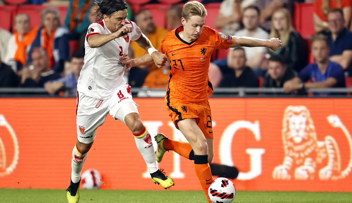 Gelandang Montenegro, Drasko Bozovic (kiri) bersaing dengan gelandang timnas Belanda Frenkie de Jong pada laga lanjutan kualifikasi Piala Dunia 2022 di Stadion Phillips, Minggu (5/8/2021) dini hari WIB. Belanda menggilas Montenegro empat gol tanpa balas. (MAURICE VAN STEEN/ANP/AFP)