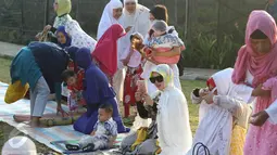 Penyanyi Syahrini memainkan ponselnya sebelum melaksanakan salat Idul Adha 1437 H di taman Tanah Sereal, Bogor, Senin (12/9). Syahrini memakai baju muslim bermotif, dilengkapi dengan luaran warna putih plus kacamata hitam. (Liputan6.com/Herman Zakharia)