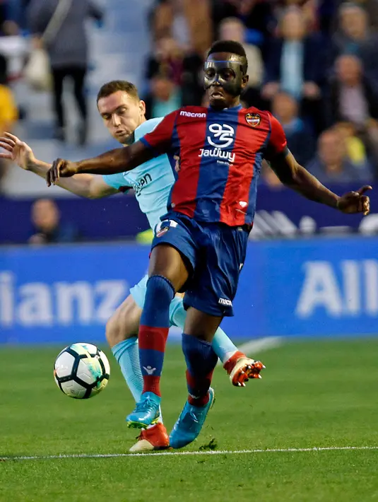 Pemain Levante, Emmanuel Boateng berebut bola dengan pemain Barcelona, Thomas Vermaelen pada jornada ke-37 La Liga di Estadio Ciudad de Valencia, Senin (14/5). Barcelona dipaksa menyerah dengan kedudukan 5-4 di markas Levante. (AP/Alberto Saiz)