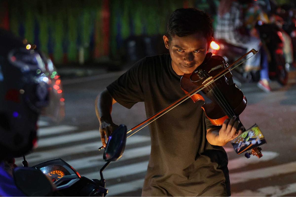 FOTO: Musik di Lampu Merah,  Kisah Kris Si Biola Jalanan dan Polemik Royalti
