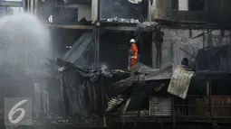 Petugas pemadam kebakaran memadamkan api yang membakar pemukiman di kawasan padat penduduk Bukit Duri, Jakarta, Selasa (23/2). Hingga kini penyebab kebakaran masih dalam penyelidikan pihak terkait. (Liputan6.com/Gempur M Surya)