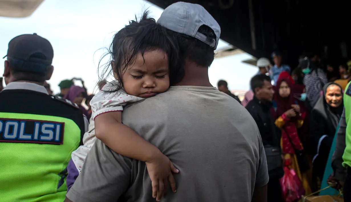 Sejumlah warga korban gempa dan tsunami Palu-Donggala turun dari pesawat saat tiba di Surabaya (4/10). Banyak anak-anak yang terpisah dari keluarganya setelah bencana gempa-tsunami melanda Palu dan Donggala pada 28 September. (AFP Photo/Juni Kriswanto)