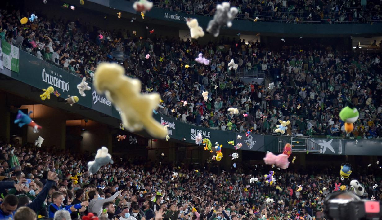 Caranya adalah para suporter di dalam stadion melemparkan mainan atau boneka yang mereka bawa ke atas rumput stadion saat jeda babak pertama. (AFP/Cristina Quicler)
