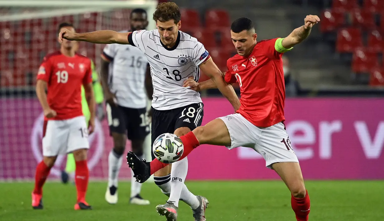 Gelandang Jerman, Leon Goretzka, berebut bola dengan gelandang Swiss, Granit Xhaka, pada laga lanjutan UEFA Nations League 2020/2021 di RheinEnergie Stadion, Rabu (14/10/2020). Jerman bermain imbang 3-3 atas Swiss. (AFP/Ina Fassbender)