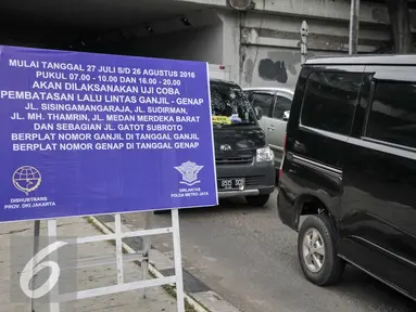 Pengendara melihat papan sosialisasi uji coba pembatasan lalu lintas ganjil-genap terpasang di underpass Dukuh Atas, Jakarta, Senin (25/7). Penerapan sistem ganjil-genap akan dimulai pada 27 Juli hingga 26 Agustus 2016. (Liputan6.com/Yoppy Renato)