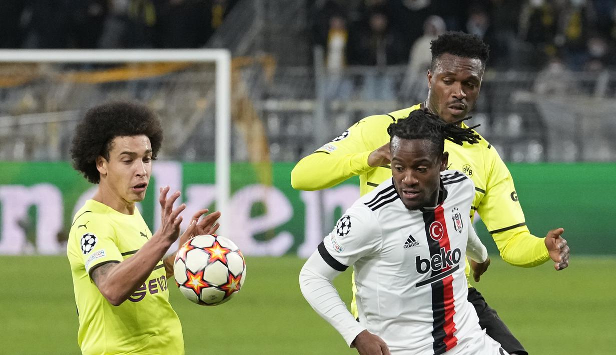 Pemain Borrusia Dortmund, Axel Witsel dan Dan-Axel Zagadou berusaha merebut bola dari pemain Besiktas Michy Batshuayi pada pertandingan Grup C Liga Champions di Signal Iduna Park, Jerman, Rabu (8/12/2021). Dortmund menang telak atas Besiktas dengan skor 5-0. (AP Photo/ Martin Meissner)