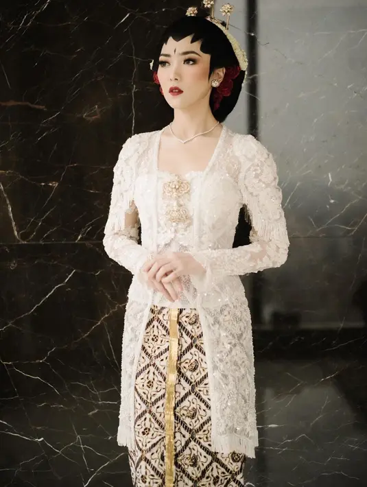 Di hari pernikahannya, Isyana Saravati sangat memukau berbalut kebaya putih model kutu baru modern. Kebaya pengantin bergaya adat Jawa ini merupakan rancangan dari desainer Didiet Maulana. (Liputan6.com/IG/@isyanasarasvati)