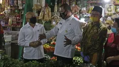 Menteri Koperasi dan UKM Teten Masduki (kiri) berbincang dengan Wakil Wali Kota Bekasi Tri Adhianto usai mengunjungi Pasar Kranggan, Bekasi, Jawa Barat, Jumat (19/6/2020). Teten meninjau restrukturisasi pinjaman/pembiayaan LPDB-KUMKM kepada Koperasi Pasar Kranggan. (Liputan6.com/Herman Zakharia)