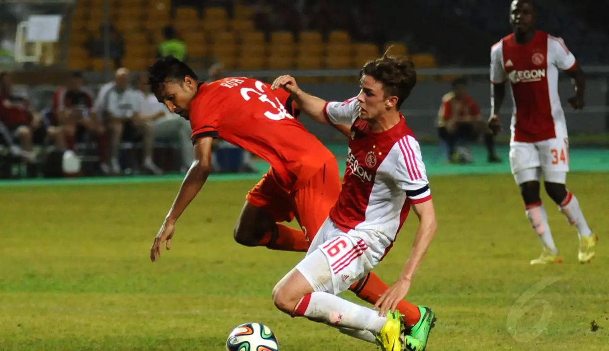 Rohit Chand (Persija-kiri) harus bermain ekstra keras menahan laju serangan pemain Ajax Amsterdam, Lucas Andersen saat berlaga di Stadion GBK Jakarta, (11/5/2014). (Liputan6.com/Helmi Fithriansyah)