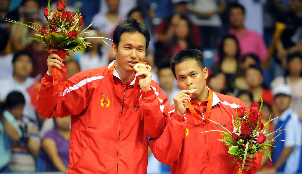 Pemain badminton Indonesia Markis Kido (kanan) dan Hendra Setiawan merayakan dengan medali emas mereka usai mengalahkan pemain badminton China Cai Yun dan Fu Haifeng pada pertandingan final ganda putra Olimpiade Beijing 2008 di Beijing, China, 16 Agustus 2008. (AFP PHOTO/GOH CHAI HIN)