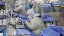 Pekerja memproduksi pakaian pelindung di sebuah pabrik di Nantong, Provinsi Jiangsu, China, Senin (27/1/2020). Pakaian pelindung tersebut diproduksi untuk mendukung pasokan bahan medis saat wabah virus corona melanda China. (STR/AFP)
