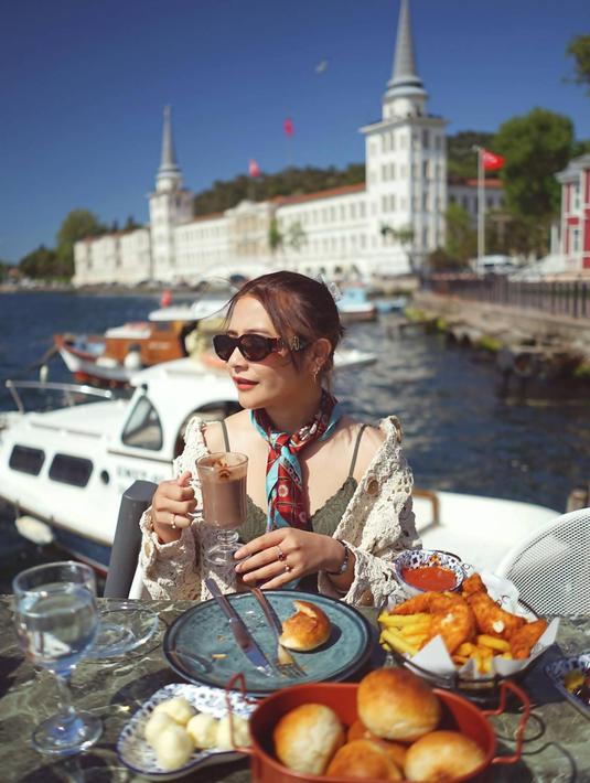 Seru menikmati berbagai menu makanan sambil memandangi lautan, tentu menjadi salah satu pengalaman seru. Seperti yang dilakukan Prilly Latuconsina saat liburan ke Turki pada bulan Mei 2022 lalu. Dalam liburannya ini ia selalu tampil stylish dan mencuri perhatian banyak netizen. (Liputan6.com/IG/@prillylatuconsina96)