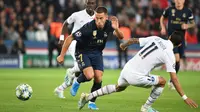 Pemain depan Real Madrid, Eden Hazard berebut bola dengan pemain sayap Paris Saint-Germain (PSG), Angel Di Maria dalam laga Grup A Liga Champions di Parc des Princes, Rabu (18/9/2019). PSG berhasil menaklukkan tamunya Real Madrid 3-0. (MARTIN BUREAU / AFP)