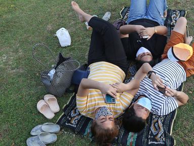 Warga beraktivitas di area hutan kota di Kompleks Gelora Bung Karno, Senayan, Jakarta, Sabtu (22/08/2020). Pengunjung memanfaatkan pemandangan dan suasana Hutan Kota GBK untuk menghabiskan libur akhir pekan di tengah pandemi Covid-19. (Liputan6.com/Herman Zakharia)