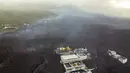 Aliran lahar menghancurkan rumah dan pabrik saat gunung berapi terus meletus di pulau Canary La Palma, Spanyol, Senin (29/11/2021). Beberapa ventilasi vulkanik baru dibuka di La Palma pada hari Minggu, melepaskan lava baru yang mengalir deras ke bawah. (AP/Emilio Morenatti)