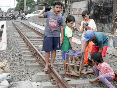 Anak-anak bermain di sekitar rel kereta api di kawasan Pademangan, Jakarta, Kamis (8/11). Kurangnya lahan bermain menyebabkan anak-anak tersebut bermain di tempat yang tidak semestinya dan membahayakan keselamatan. (Liputan6.com/Immanuel Antonius)