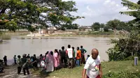 Warga menyaksikan proses evakuasi perahu terbalik di Bengawan Solo. (Ahmad Adirin/Liputan6.com)