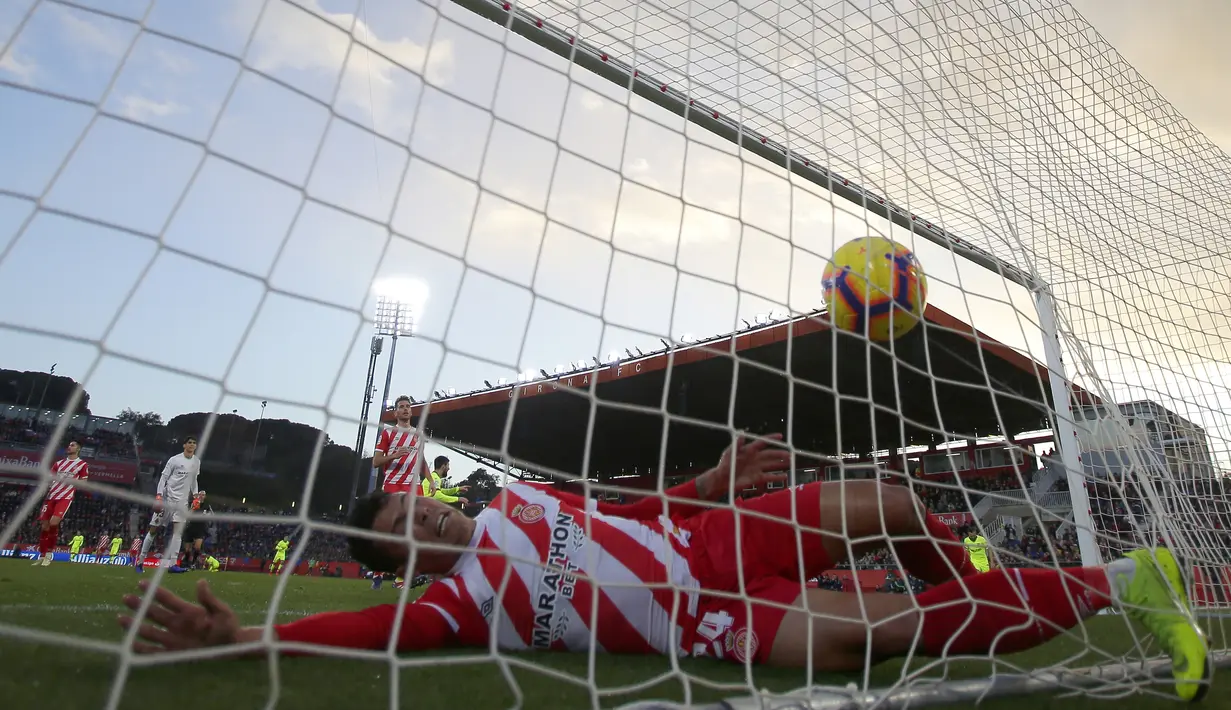 Bek Girona gagal menghalau tendangan striker Barcelona, Lionel Messi, pada laga La Liga di Stadion Montilivi, Minggu (27/1). Barcelona menang 2-0 atas Girona. (AP/Manu Fernandez)
