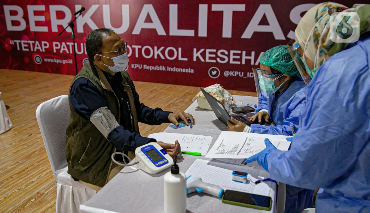 Petugas medis mendata dan memeriksa kondisi karyawan di lingkungan KPU RI saat vaksinasi COVID-19 di Gedung KPU, Jakarta, Rabu (17/3/2021). Sebanyak 549 karyawan di lingkungan KPU RI mengikuti vaksinasi COVID-19. (Liputan6.com/Faizal Fanani)