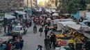 Warga Suriah memadati pasar untuk membeli produk makanan menjelang buka puasa pada hari kedua bulan Ramadhan, di kota Ariha yang dilanda perang, di provinsi Idlib, Kamis (15/4/2021). Mereka menjalankan Ramadhan di antara lautan reruntuhan bekas konflik gencatan senjata. (Omar HAJ KADOUR/AFP)