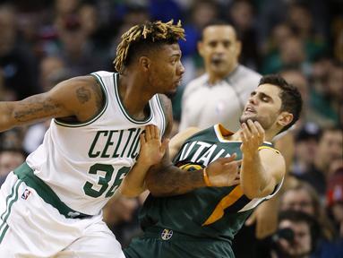 Pemain Boston Celtics, Marcus Smart (36) mencoba melewati hadangan pemain Utah Jazz, Raul Neto (25) pada lanjutan NBA di TD Garden. Boston Celtics menang 115-104.  (Reuters/Greg M. Cooper-USA TODAY Sports)