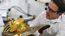 Christian Eckmann, kolektor benda bersejarah asal Jerman melihat kondisi topeng emas Raja Tutankhamun di museum Mesir, Kairo, Selasa (20/10/2015). Topeng emas Tutankhamun terdiri dari 11 kg emas murni. (REUTERS/Mohamed Abd El Ghany)