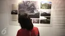 Pengunjung memperhatikan karya foto pada pameran foto Anugerah Pewarta Foto Indonesia (APFI) ke-VI di Gedung De Vries, Bandung, Sabtu (9/4). APFI 2016 memamerkan 25 foto tunggal dan tiga foto seri terbaik sepanjang  2015. (Liputan6.com/Faizal Fanani)