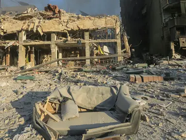 Seorang pria berjalan melewati bangunan yang hancur dan rusak di lokasi serangan udara Israel semalam yang menargetkan pinggiran selatan Beirut pada 27 Oktober 2024. (Foto oleh AFP)