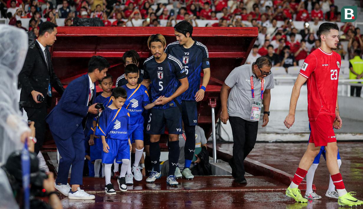 <p>Pemain Jepang, Hidemasa Morita menuntun anak kecil yang ditugaskan sebagai player escort dalam pertandingan lanjutan putaran ketiga Grup C Kualifikasi Piala Dunia 2026 melawan Timnas Indonesia di Stadion Utama Gelora Bung Karno (SUGBK), Senayan, Jakarta, Jumat (15/11/2024). (Bola.com/Bagaskara Lazuardi)</p>