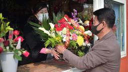 Seorang pria mengunjungi kios bunga untuk membeli sekeranjang bunga sebagai hadiah selama perayaan Hari Perempuan Internasional di Pyongyang, Korea Utara, Rabu 8 Maret 2023. Melansir laman International Women's Development Agency, Hari Perempuan Internasional adalah momen bagi masyarakat dunia untuk menyuarakan hak-hak perempuan di semua lini kehidupan, mulai dari sosial, politik, ekonomi hingga budaya. (KIM Won Jin/AFP)