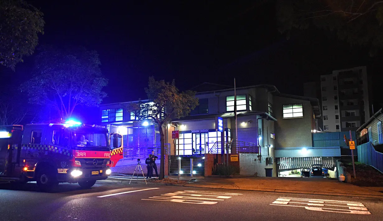 Personel kepolisian berjaga setelah seorang pria yang mengendarai mobil berisi tabung gas dan menabrak pintu gerbang markas polisi Merrylands, Sydney Barat, Kamis (21/7). Pria itu sebelumnya mengklaim membawa bom. (SAM Mooy/POOL /AFP)