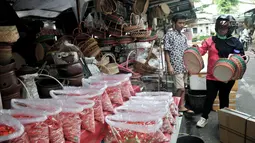 Pedagang melayani pembeli di salah satu kios kembang makam di Pasar Rawa Belong, Jakarta, Senin (29/4). Pedagang mengaku omzet mereka meningkat tiga kali lipat dari bulan biasanya pada musim ziarah kubur atau nyekar jelang Ramadan. (merdeka.com/Iqbal Nugroho)