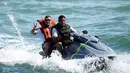 Bersama petugas keamanan pantai Brasil, pemain depan Timnas Jerman, Lukas Podolski (belakang) berlayar menggunakan jetski di salah satu pantai dekat Santo Andre, Sao Paolo, (10/6/2014). (AFP PHOTO/Markus Gilliar)