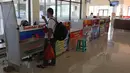 Penjaga tiket bus berbincang dengan calon penumpang di Terminal Jatijajar, Depok, Jawa Barat, Senin (6/7/2020). Terminal tipe A tersebut kembali mengoperasikan layanan bus Antar Kota Antar Provinsi (AKAP) dengan menerapkan protokol kesehatan. (Liputan6.com/Herman Zakharia)