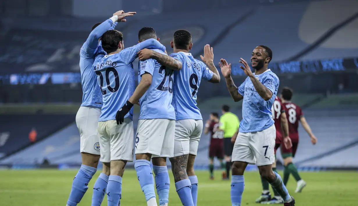 Penyerang Manchester City, Raheem Sterling bersama rekannya merayakan gol pembuka ke gawang Wolves pada pertandingan Liga Inggris di stadion Etihad, Rabu (3/3/2021).  Dengan hasil ini, Manchester City sudah meraih 15 kemenangan beruntun di Liga Inggris. (Carl Recine/Pool via AP)