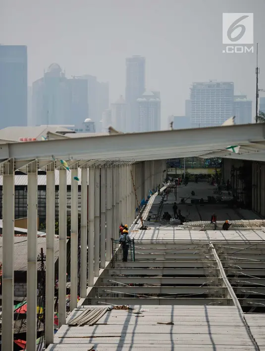 Pekerja menyelesaikan proyek pembangunan jembatan multiguna (skybridge) Tanah Abang di Jakarta, Selasa (9/10). Pembangunan skybridge yang dimulai pada 3 Agustus lalu itu baru mencapai setengah jalan atau 58 persen. (Liputan6.com/Faizal Fanani)