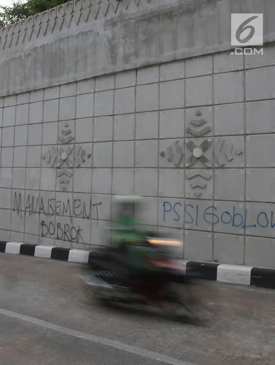 Pengendara motor melewati coretan di dinding underpass atau lintas bawah Matraman, Jakarta Selatan, Rabu (2/5). Corat-coret tersebut terpampang jelas ketika melintas dari arah Jalan Tambak menuju kawasan Pramuka. (Liputan6.com/Arya Manggala)