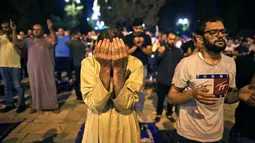 Seorang muslim Palestina khusyuk berdoa saat berburu malam Lailatul Qadar di luar Kubah Batu (Dome of the Rock) di kompleks Masjid Al-Aqsa di Yerusalem (8/5/2021). (AFP/Ahmad Gharabli)