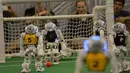 Sejumlah Robot melakukan pertandingan sepak bola di ajang RoboCup 2015 yang digelar di Hefei, provinsi Anhui, Cina (22/7/2015). Salah satu robot terlihat mencoba melewati robot lainnya saat bertanding. (AFP/Stringer)