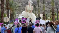 Para pengunjuk rasa berkumpul di depan patung "Forever Marilyn" di Palm Springs, California,  20 Juni 2021. (Frederic J. BROWN/AFP)
