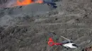 Sebuah helikopter terbang di dekat puncak Gunung Piton de la Fournaise, Prancis, Rabi (1/2). Gunung tersebut kembali meletus pada Selasa (31/1) malam waktu setempat dan terus menyemburkan lava pijar. (AFP Photo/Richard Bouhet)