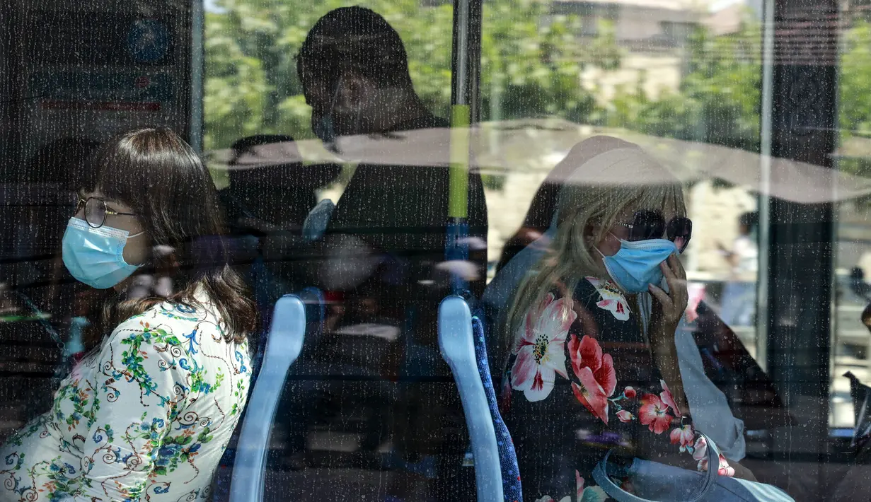 Warga Israel mengenakan masker di dalam bus, setelah pihak berwenang memperketat pembatasan, di Yerusalem, Kamis (19/8/2021). Pemerintah setempat kembali memperketat perbatasan pada Rabu (18/8) saat Israel mencatat angka infeksi harian Covid-19tertinggi sejak Januari. (MENAHEM KAHANA/AFP)